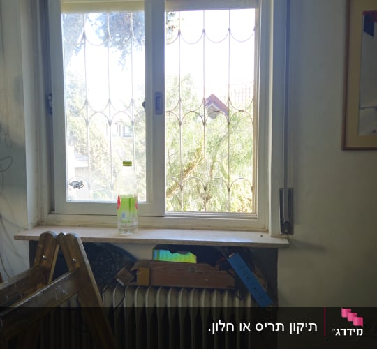 חלון עם תריסים וסולם בחדר פנימי